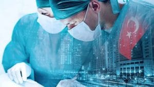 A male and female doctor wearing blue gowns and wearing masks