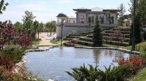  villa overlooking a lake surrounded by trees and green grass