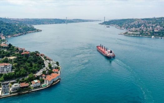 A ship passing through the waters of the Bosphorus Strait, parallel to the Istanbul Canal, in Yenişehir