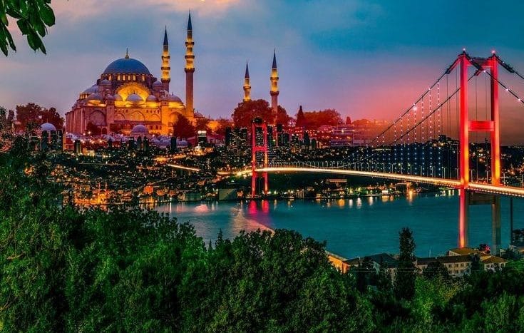 The city of Istanbul at night, showing the Bosphorus Bridge passing over the Bosphorus Strait, illuminated by lights